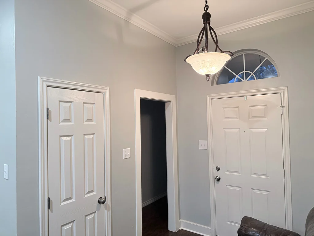 Entry repainted gray with crisp white trim around the front door and arched transom