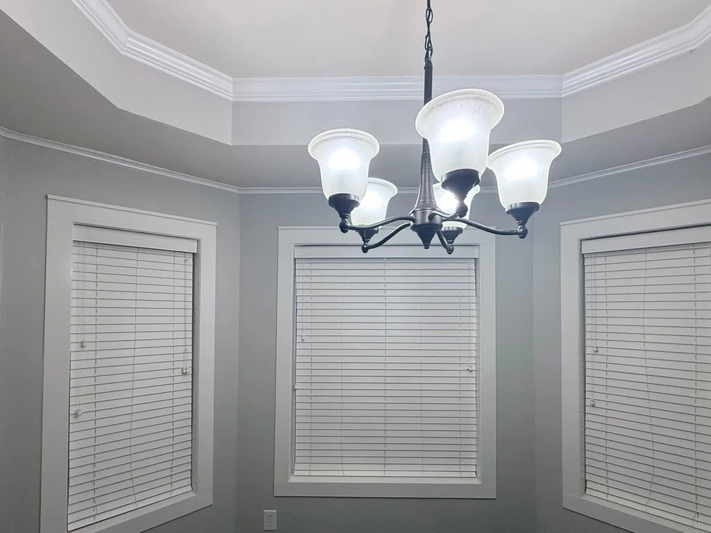Matched after view of the dining nook, gray walls and white trim under the tray ceiling
