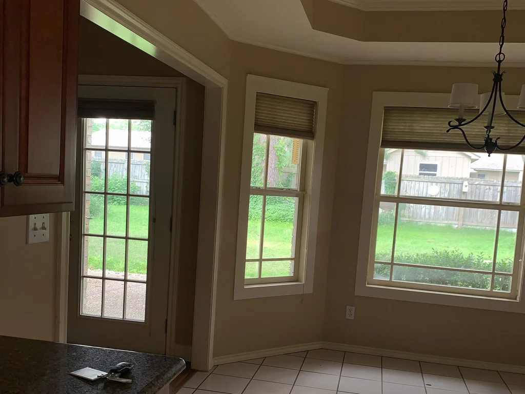 Matched before view of the dining nook, tan walls and trim around the rear windows
