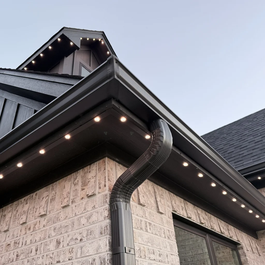 Close view of warm white bulbs flush in a dark soffit channel at a gutter corner