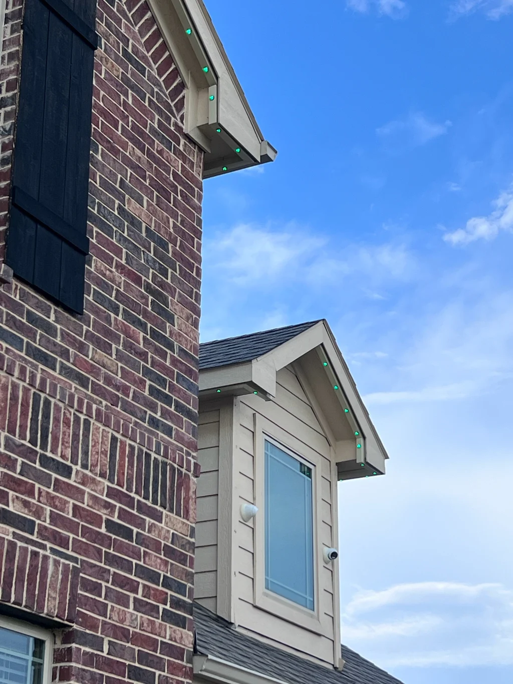 Daylight view of lighting track along a dormer roof against a blue sky