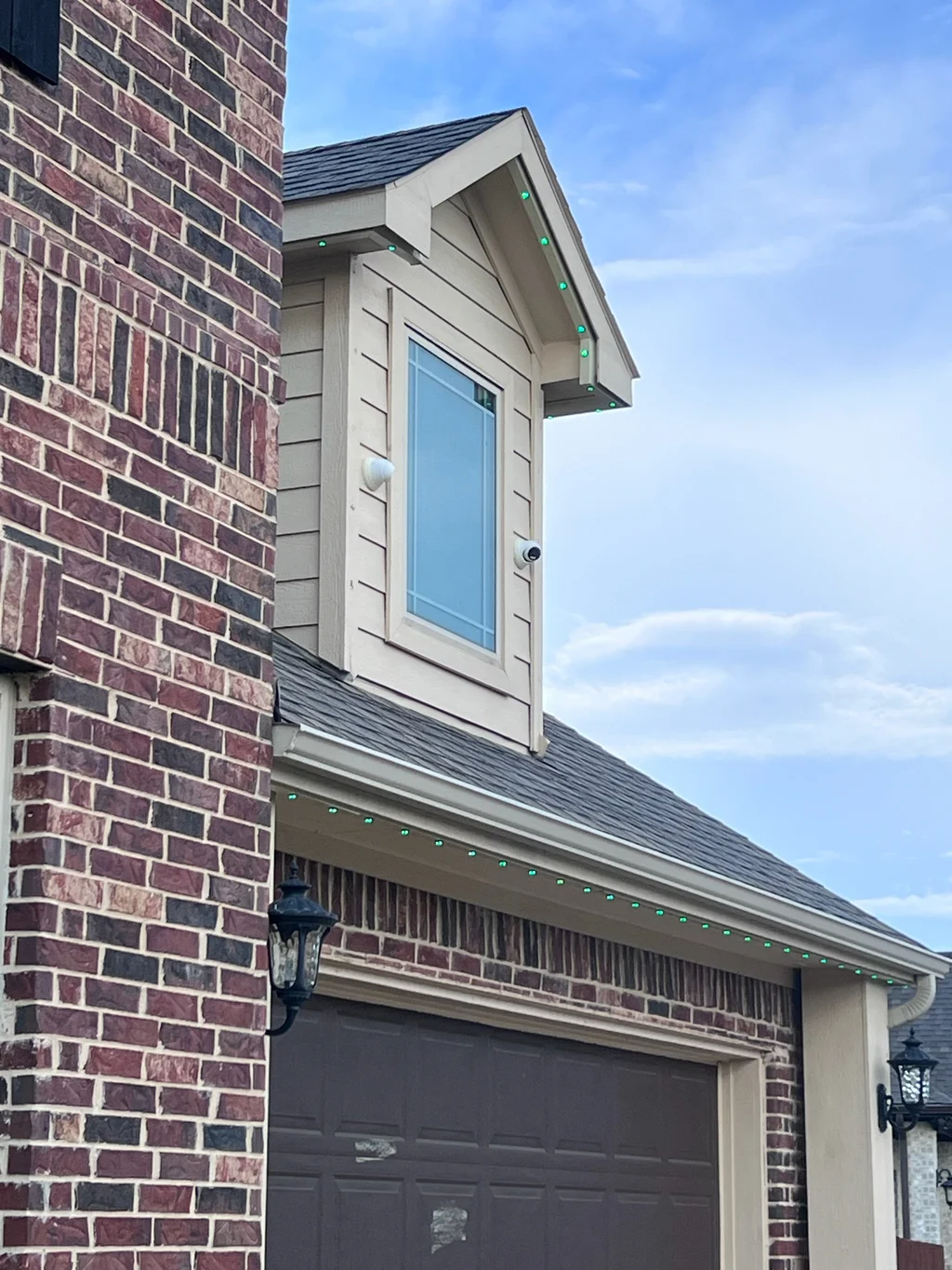 Daylight track following a dormer roof and the garage roofline below on red brick